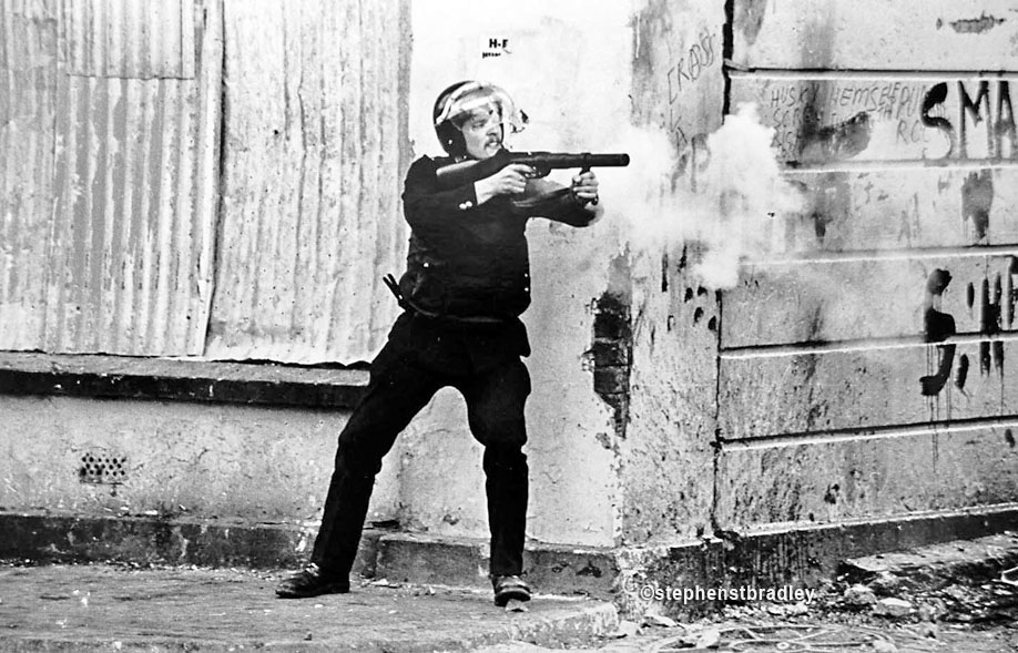 RUC officer firing plastic bullet gun, Ardoyne, Belfast, Northern Ireland, by Stephen S T Bradley, editorial, commercial, PR and advertising photographer, Dublin, Ireland