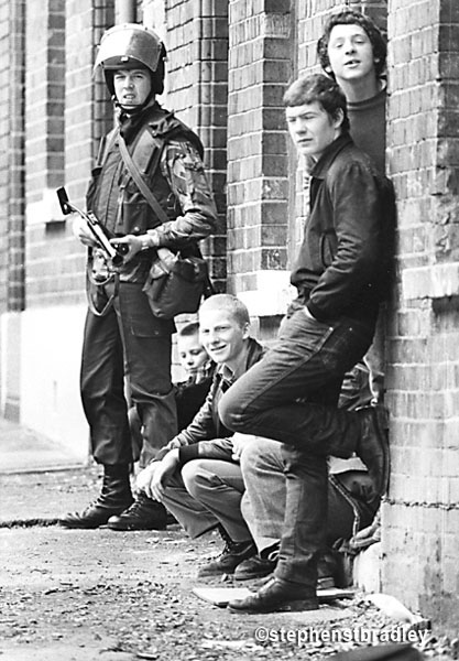 Image - Young British solider on foot patrol beside young men of similar age, New Lodge, Belfast by Stephen S T Bradley, editorial, commercial, PR and advertising photographer, Dublin, Ireland