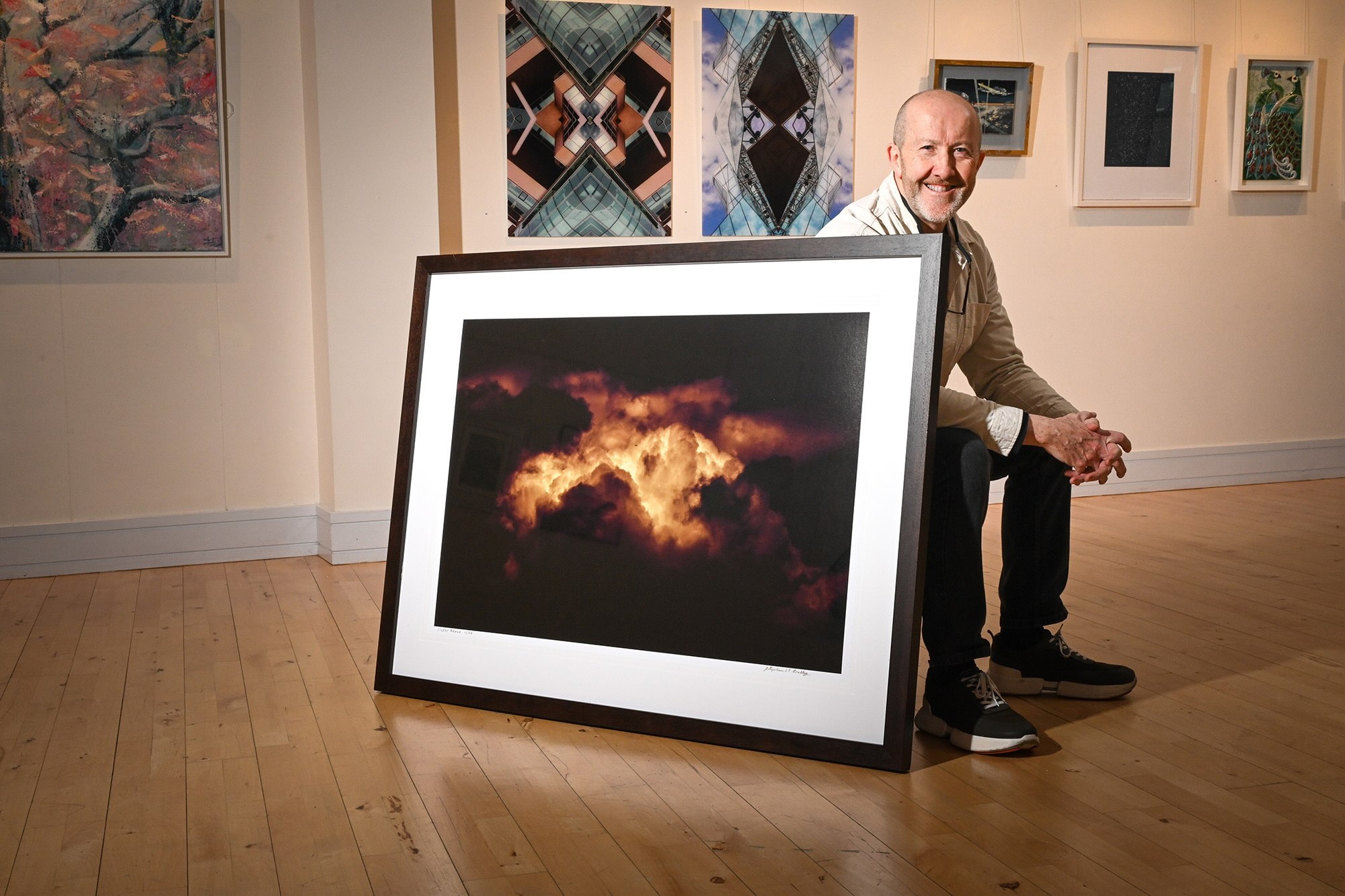 Stephen S T Bradley - Photography Curator Ireland: Silver Skies Announcement Photography curator Ireland Stephen S T Bradley in the gallery space at ISLAND Arts Centre during the official announcement of the centre's first-ever open call photography exhibition. Seated beside his fine art photograph 'Silent Redux', Bradley outlined the curatorial framework for the 'Silver Skies' exhibition, which celebrates the venue's 25th Silver Anniversary.